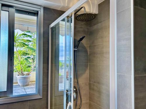 une salle de bain avec une douche avec une porte vitrée dans l'établissement LES ANGES -F2 Appartement, terrasse vue mer, piscine, wifi, à Villeneuve-Loubet