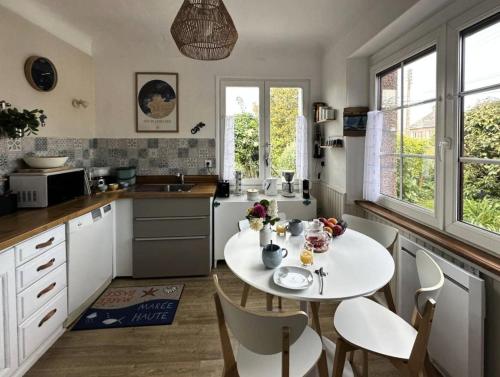 - une cuisine avec une table et des chaises blanches dans la chambre dans l'établissement Résidence R42-pleumeur Bodou - Maison de charme près de la plage MAE-3754, à Pleumeur-Bodou