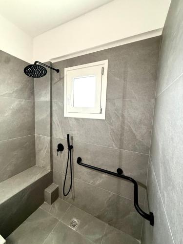 a bathroom with a shower and a window at PETRA Luxury Villas in Áyioi Apóstoloi