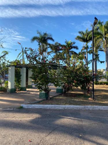 a building with palm trees and a street light at Quarto Econômico no Centro para 2 Pessoas in Sete Lagoas