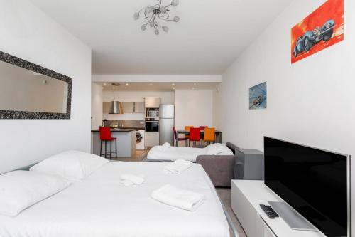 un salon avec un lit et une télévision à écran plat dans l'établissement CIPRIANI-Perle rare vue mer proche Monaco, piscine, parking, à Beausoleil