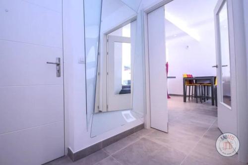 une salle de bain avec une porte vitrée et une pièce avec une table dans l'établissement CIPRIANI-Perle rare vue mer proche Monaco, piscine, parking, à Beausoleil