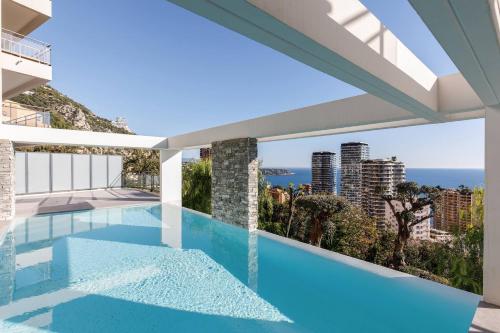 - une vue depuis le balcon d'une maison avec piscine dans l'établissement CIPRIANI-Perle rare vue mer proche Monaco, piscine, parking, à Beausoleil