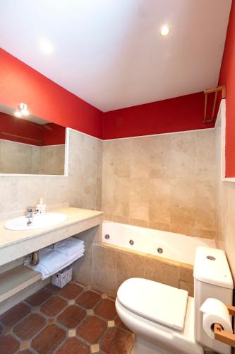 a bathroom with a toilet and a sink and a tub at La Casa de la Iglesia in Mijas