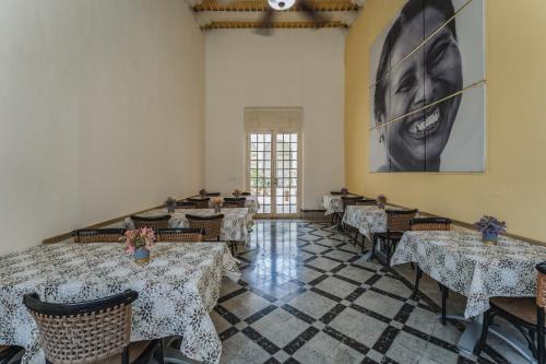 a dining room with tables and a picture of a woman at Hotel Boutique La Casona by Kavia in Mérida