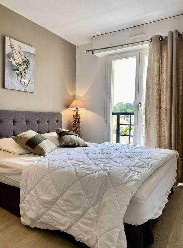 une chambre avec un grand lit blanc avec une fenêtre dans l'établissement Résidence Antares - Arcachon – T2 à deux pas du centre-ville et de la plage MAE-9284, à Arcachon
