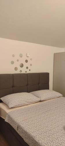 a bed in a room with avertisement at Apartmani Maslina Žuljana in Žuljana
