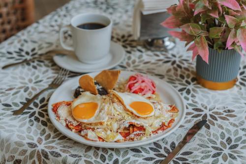 a plate of eggs on a table with a cup of coffee at Hotel Boutique La Casona by Kavia in Mérida
