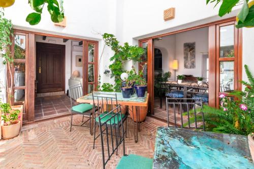 a patio with a table and chairs and plants at La Casa de la Iglesia in Mijas