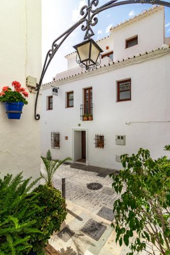 a white building with a light attached to it at La Casa de la Iglesia in Mijas