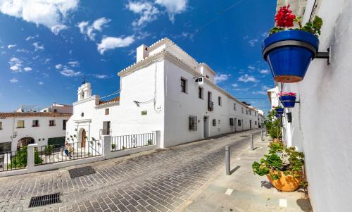 a street with white buildings and a blue bucket at La Casa de la Iglesia in Mijas