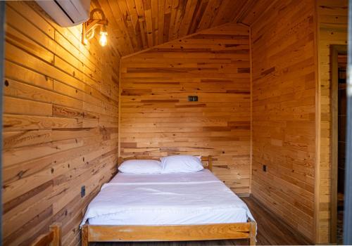 a wooden cabin with a bed in it at Reflections Camp in Faralya