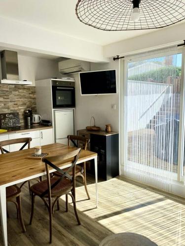 une cuisine et une salle à manger avec une table en bois dans l'établissement Résidence Les Perlieres - Arcachon – Charmant T1 Cabine décoré avec soin, pour 2 personnes MAE-3194, à Arcachon