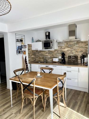 une cuisine avec une table et des chaises en bois dans l'établissement Résidence Les Perlieres - Arcachon – Charmant T1 Cabine décoré avec soin, pour 2 personnes MAE-3194, à Arcachon