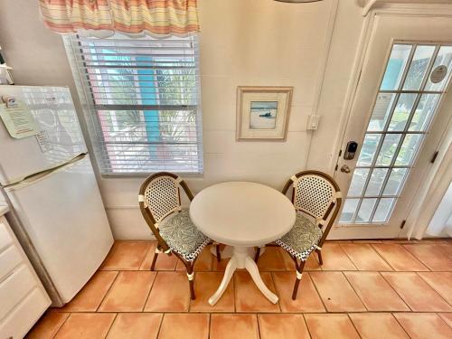 a kitchen with a table and two chairs and a refrigerator at Miami-2BR-Across from Beach in St. George Island
