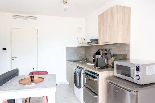 La cuisine est équipée d'un four micro-ondes et d'un évier. dans l'établissement STELLA- Studio climatisé proche Monaco, à Beausoleil