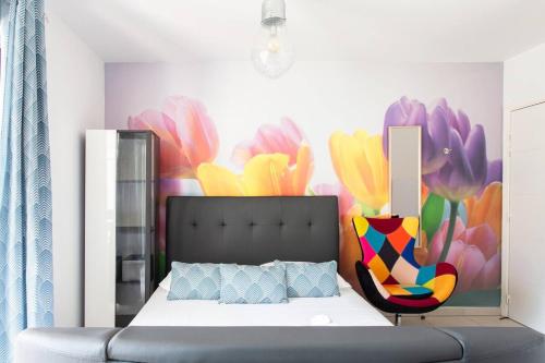 - une chambre avec un lit et une fresque murale fleurie dans l'établissement STELLA- Studio climatisé proche Monaco, à Beausoleil