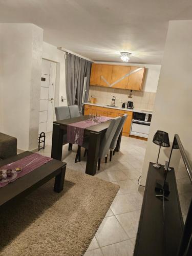 a kitchen and dining room with a table and chairs at Apartmani Sabotic in Sutomore