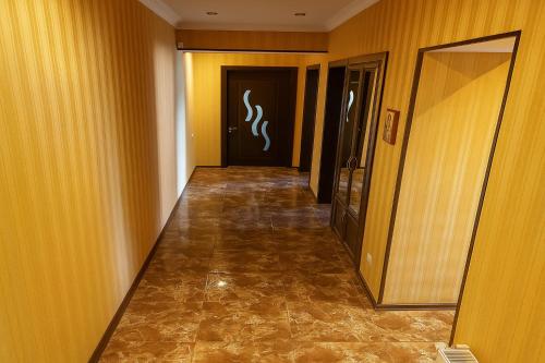 a hallway of a hotel with yellow walls and a door at GOAL ApartmentS 2 in Tbilisi City