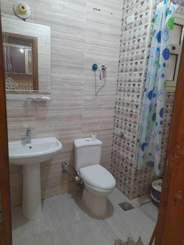 a bathroom with a toilet and a sink and a shower at White Bay Ras Sedr وايت باي راس سدر in Ras Sedr