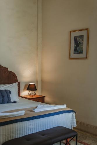 a bedroom with a bed and a lamp on a table at Hotel Boutique La Casona by Kavia in Mérida