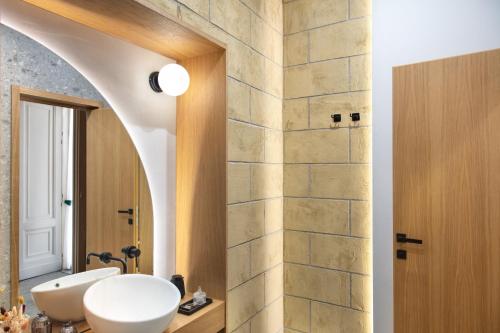 a bathroom with two sinks and a stone wall at Fortunella Suites Luxury in Portici