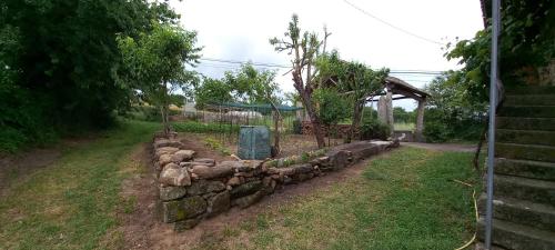 a stone wall in a yard with a fence at Casa dos ánxeles VUT-OR-1310 in Trasmiras