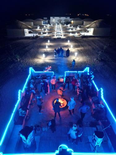 a group of people sitting around a fire at night at iMei Lux Camp 爱梅野奢营地 in Lac Yasmins