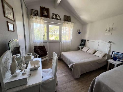 une chambre avec un lit, une table et une fenêtre dans l'établissement Résidence Les Arros - 087 - Charmante maison sur 2 niveaux aux Arros MAE-6121, à Soulac-sur-Mer