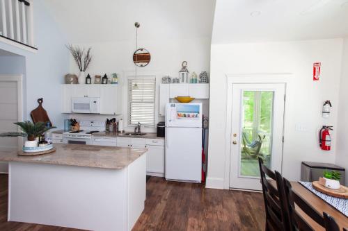 a kitchen with white cabinets and a white refrigerator at The Spring Peeper - 28 Hollow in Cherry Valley
