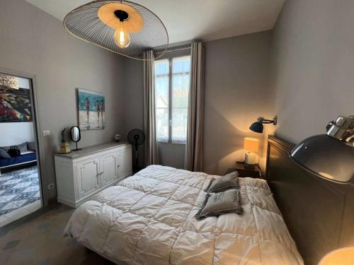 ein Schlafzimmer mit einem Bett und einem großen Fenster in der Unterkunft Résidence 191-soulac Sur Mer - 191 - Villa Soulacaise de charme au cœur de Soulac-sur-Mer MAE-9123 in Soulac-sur-Mer