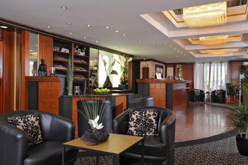 a waiting room with leather chairs and a table at Best Western Hotel zur Post in Bremen