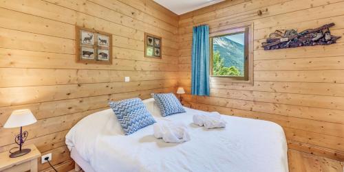 une chambre avec un lit dans une cabane en rondins dans l'établissement Résidence Les Alpages - 3 Pièces pour 6 Personnes MAE-9621, à Champagny-en-Vanoise