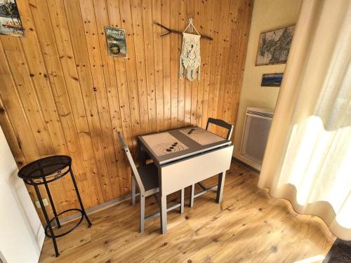 - une table et des chaises dans une chambre dotée d'un mur en bois dans l'établissement Résidence Le Saint Charles A - Studio idéalement bien situé à 50 m des Thermes Chevalley ! MAE-1223, à Aix-les-Bains
