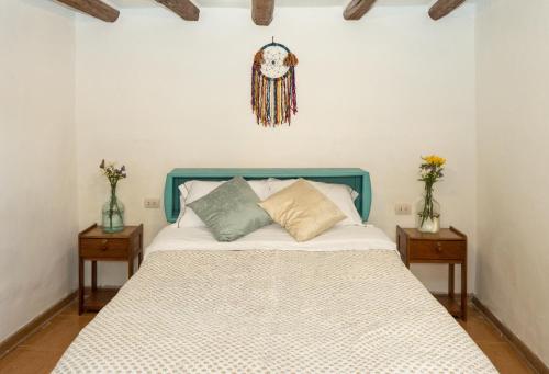 a bedroom with a bed with two nightstands and two vases at Magic House Experience in Cusco