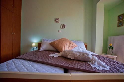 a bedroom with a bed with purple sheets and pillows at Villa Frati Gorge in Fratíon