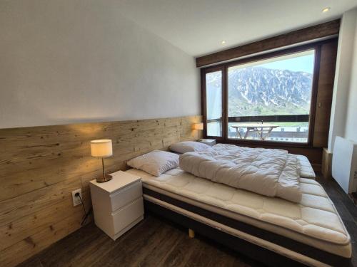 une chambre avec un lit avec une grande fenêtre dans l'établissement Résidence Bec Rouge - Appartement rénové·Skis aux pieds·Balcon MAE-6213, à Tignes