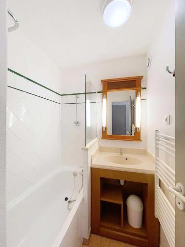 une salle de bain avec un lavabo, une baignoire et un miroir dans l'établissement Résidence Lacanau Les Pins - Appart 4 personnes résidence de tourisme avec piscine Lacanau MAE-0721, à Lacanau