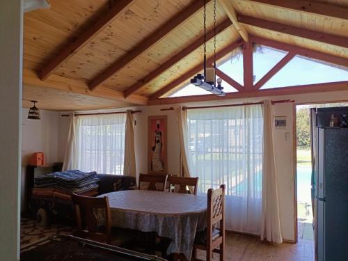 a dining room with a table and a large window at Rincon del Campo in La Serena