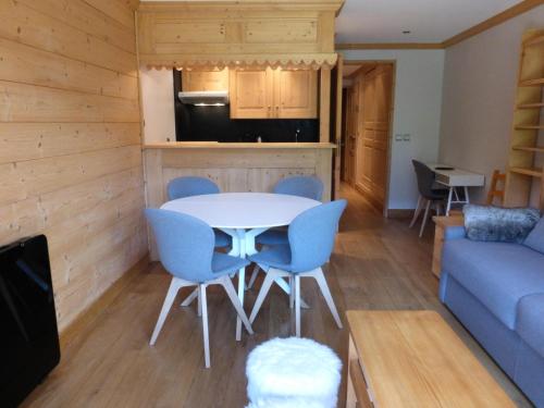 un salon avec une table, des chaises et un canapé dans l'établissement Résidence Le Vallon - Appartement 2 pièces pour 4-5 personnes situé à Méribel centre proche des commerces et des pistes de ski MAE-1766, à Les Allues