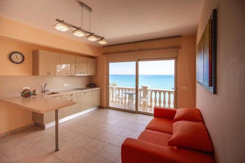 a living room with a couch and a kitchen with a balcony at Seaside Villa Margarita in Akrotiri