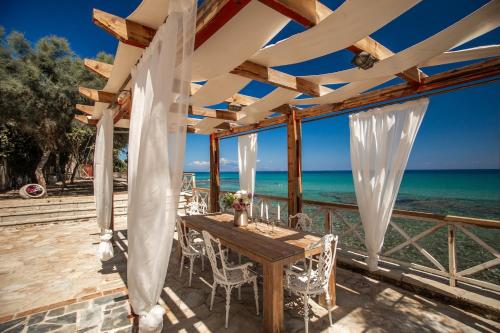 a wooden table and chairs on a deck with the ocean at Seaside Villa Margarita in Akrotiri
