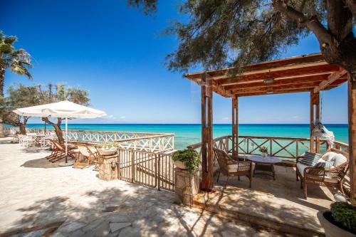 a beach with chairs and an umbrella and the ocean at Seaside Villa Margarita in Akrotiri