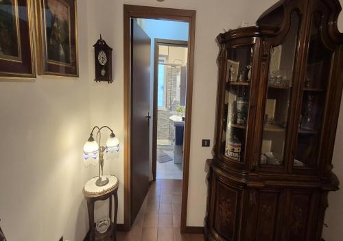 a hallway with a clock and a lamp on a table at EUR Fenix Apartment free parking family in Rome