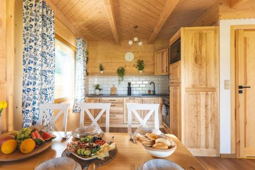 a wooden kitchen with a table with food on it at Domki Krupa Chochołów 400 m od terem in Chochołów