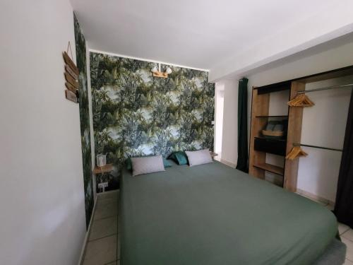 a bedroom with a green bed in a room at Ti cocon nature in Sainte-Anne