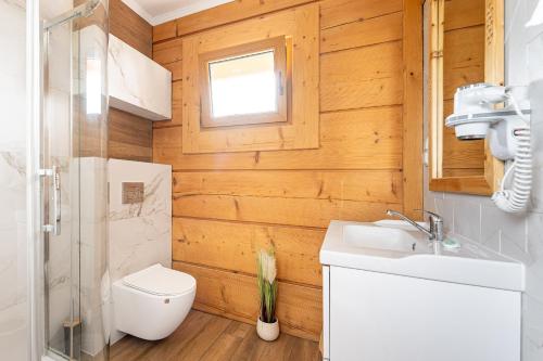 a bathroom with a toilet and a sink and a window at Domki Krupa Chochołów 400 m od terem in Chochołów
