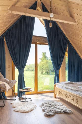 a bedroom with blue curtains and a bed and a window at Domki Krupa Chochołów 400 m od terem in Chochołów