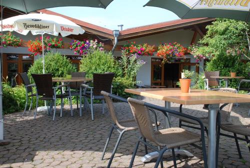 an outdoor patio with tables and chairs and flowers at Ferienwohnungen Landgasthaus Janshen in Ellscheid