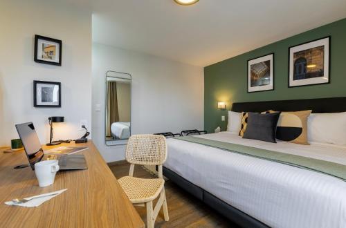 1 dormitorio con 1 cama grande y escritorio con ordenador portátil en Magis Downtown Juarez by Capitalia, en Ciudad de México